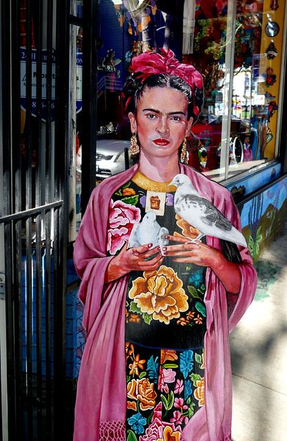 the start of this photograph series: walking to kazan and back 3.0; frida kahlo figure in front of a store on 24th street