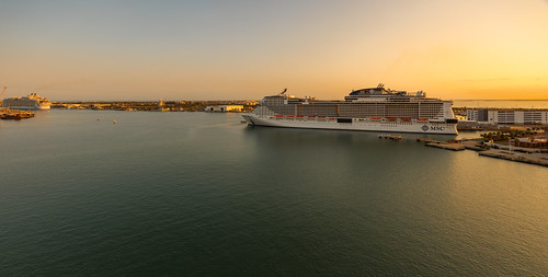 Sunset In Port Canaveral by TerryDOtt, Looking out at two large cruise ships (the MSC Meraviglia and a Royal Caribbean ship) preparing to l