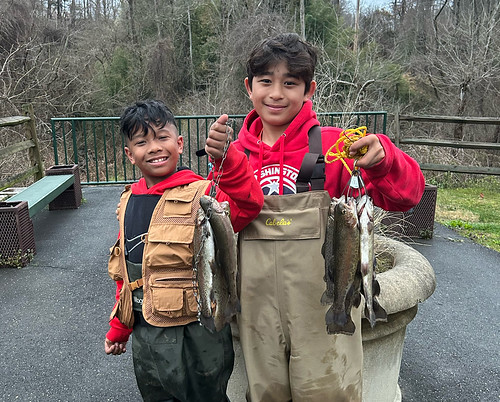 Photo of two boys holding trout on fishing lines