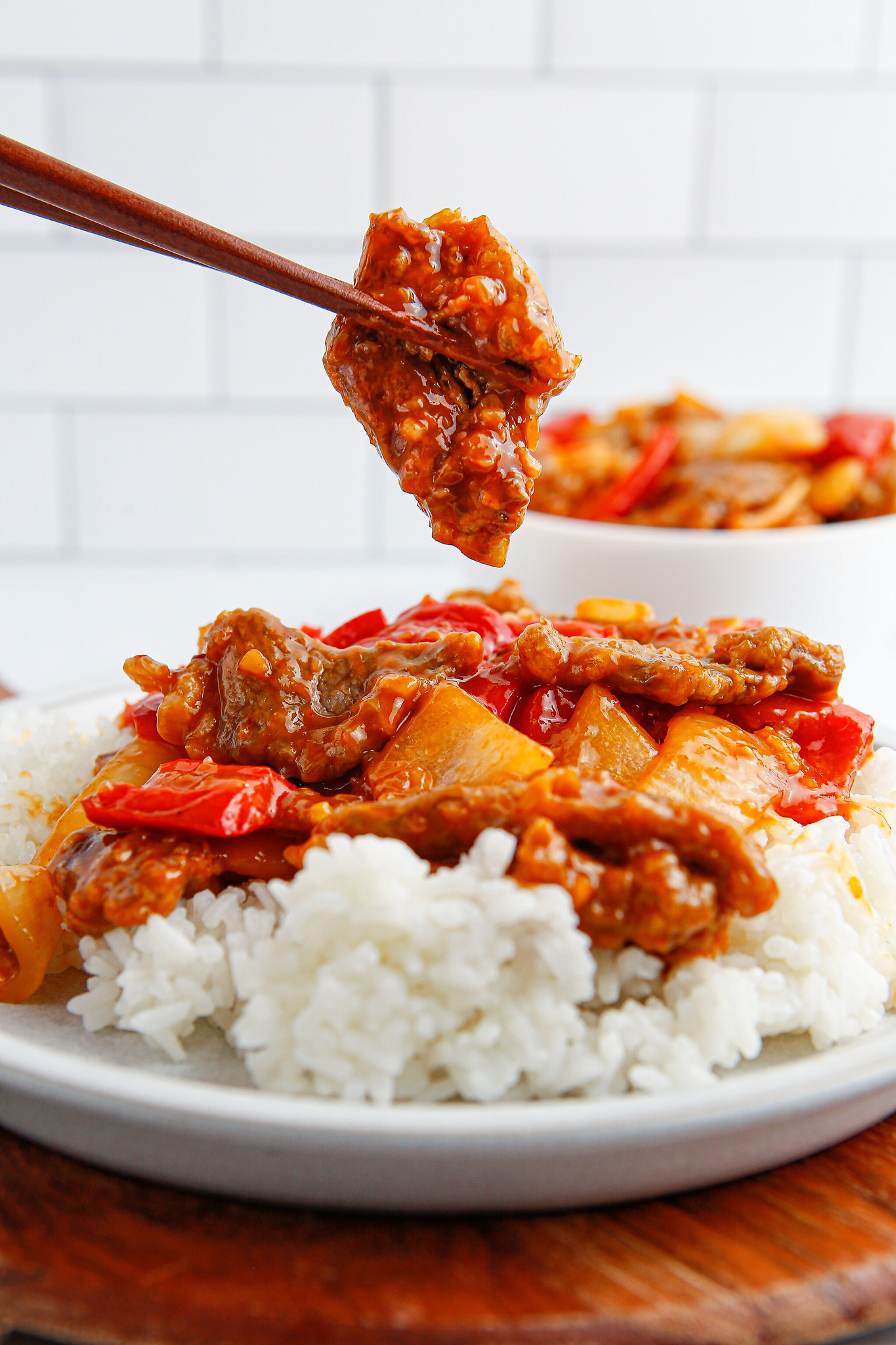 Stir fried beef, onions, and red bell peppers in a sweet and spicy sauce, served over white rice