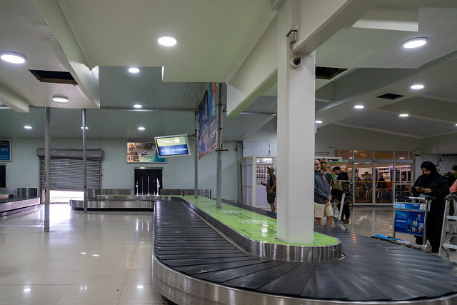 Zanzibar, Tanzania - March 14, 2023: Passengers wait for their luggage at the baggage claim belts at the ZNZ Zanzibar International Airport