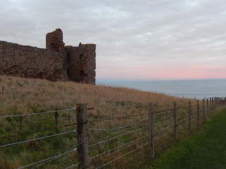 Fence at Dunstanburgh Castle at sunset