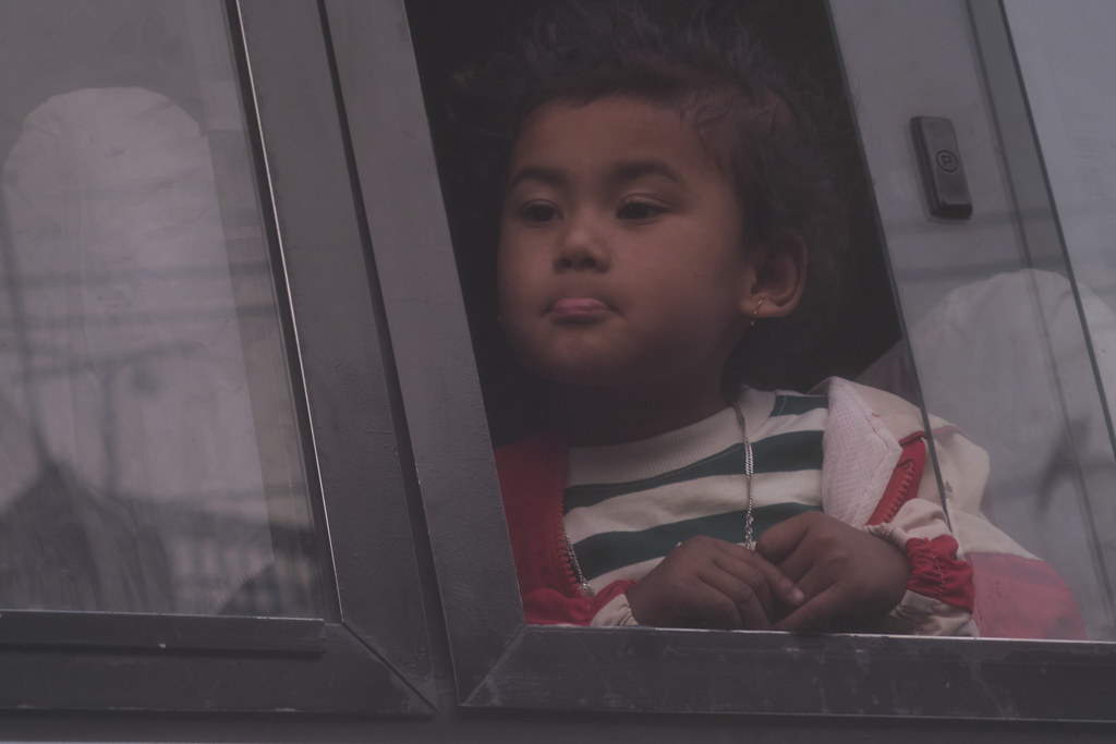 A child looks out a  bus window, Jadibuti, Kathmandu