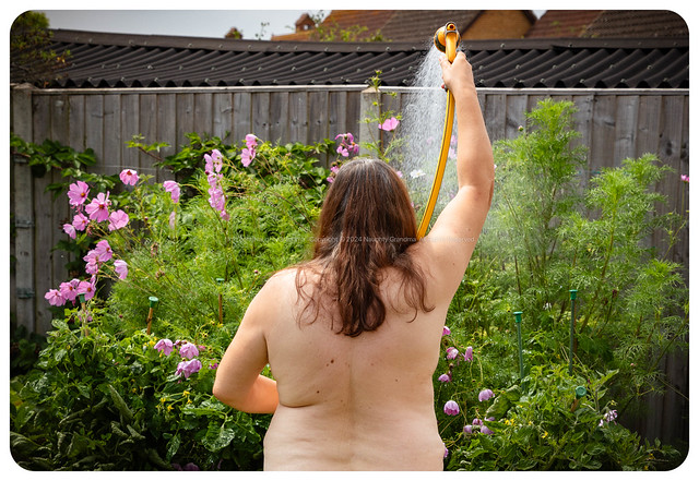 Naughty Grandma watering the flowers. Polite comments are welcome.