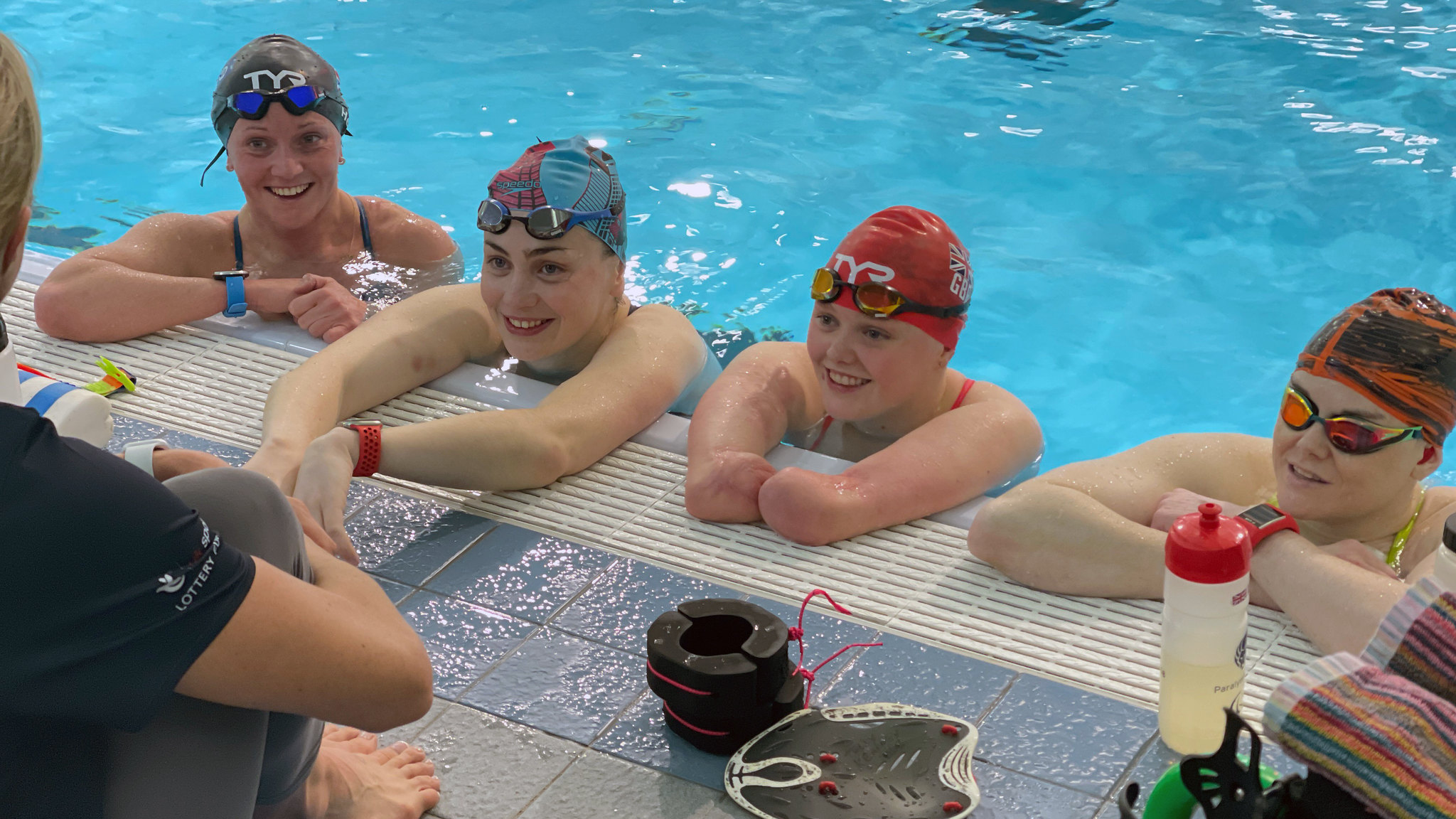 (From left) Suzanna Hext, Tully Kearney and Ellie Challis in the London 2012 Legacy Pool at the Team Bath Sports Training Village talking to coach Lauren Jocelyn. CREDIT: British Swimming.