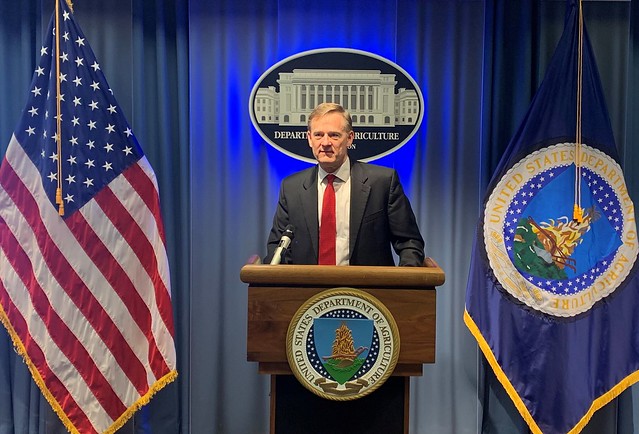Bruce Ahrendsent behind a podium with U.S. Department of Agriculture seal
