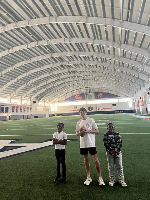 Carson Bedics and children in the Project Uplift program exploring the Auburn football facility. 