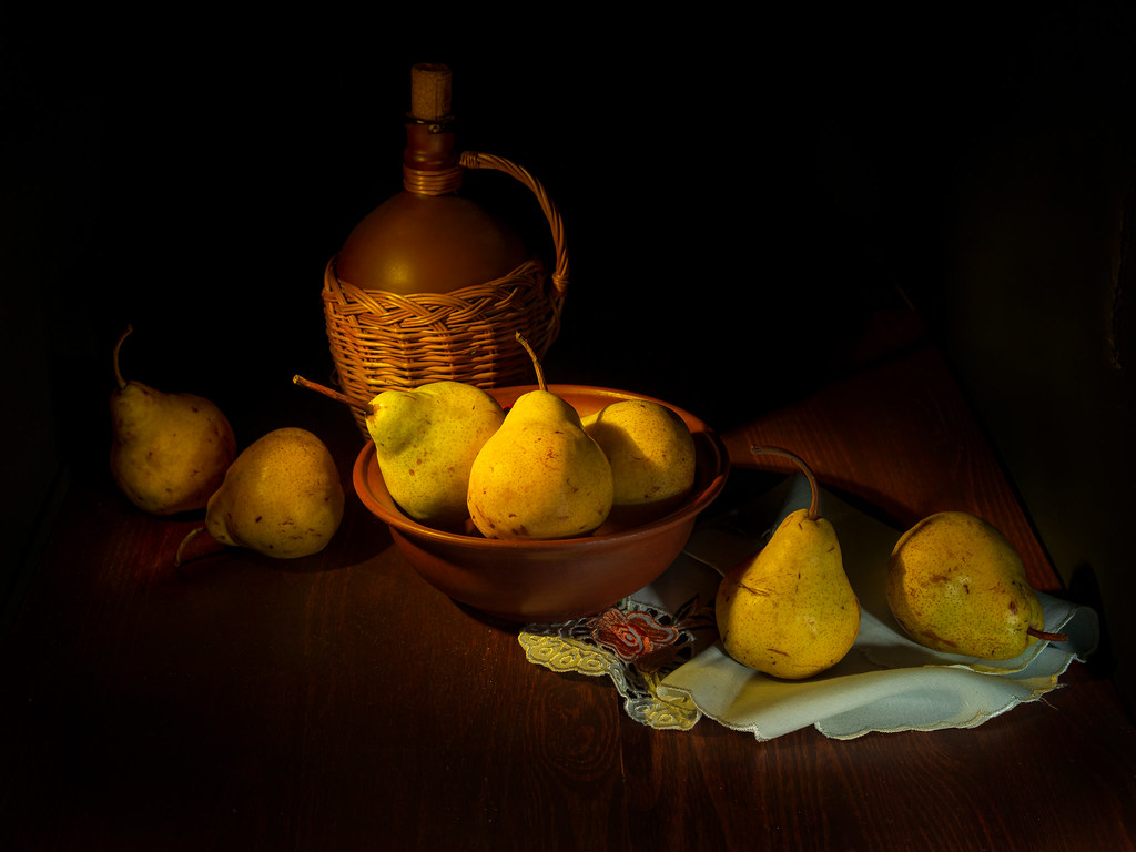 Ripe yellow pears on a wooden table and black background. Still life