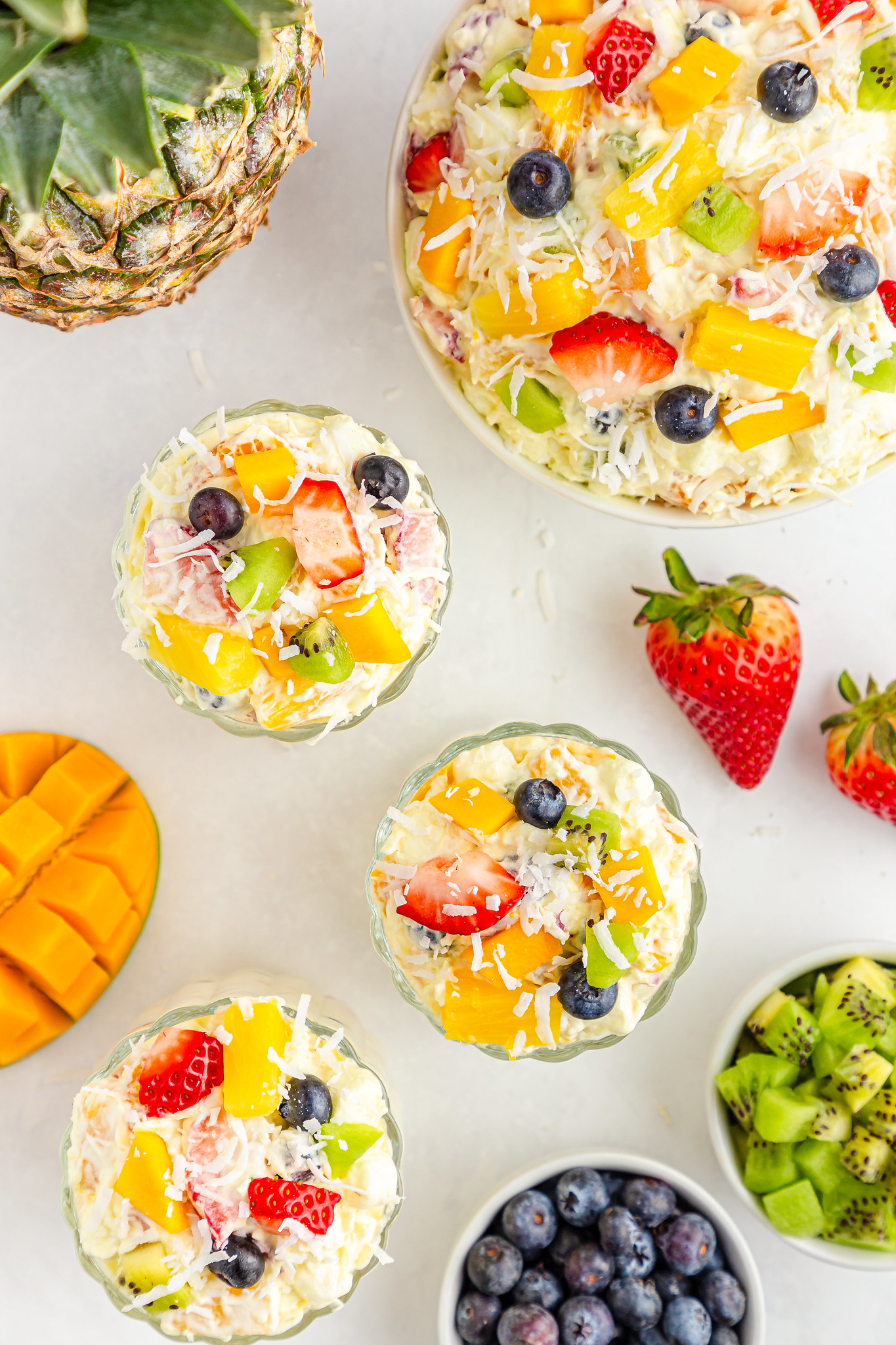 Overhead shot of 3 cups of fruit salad with coconut on top