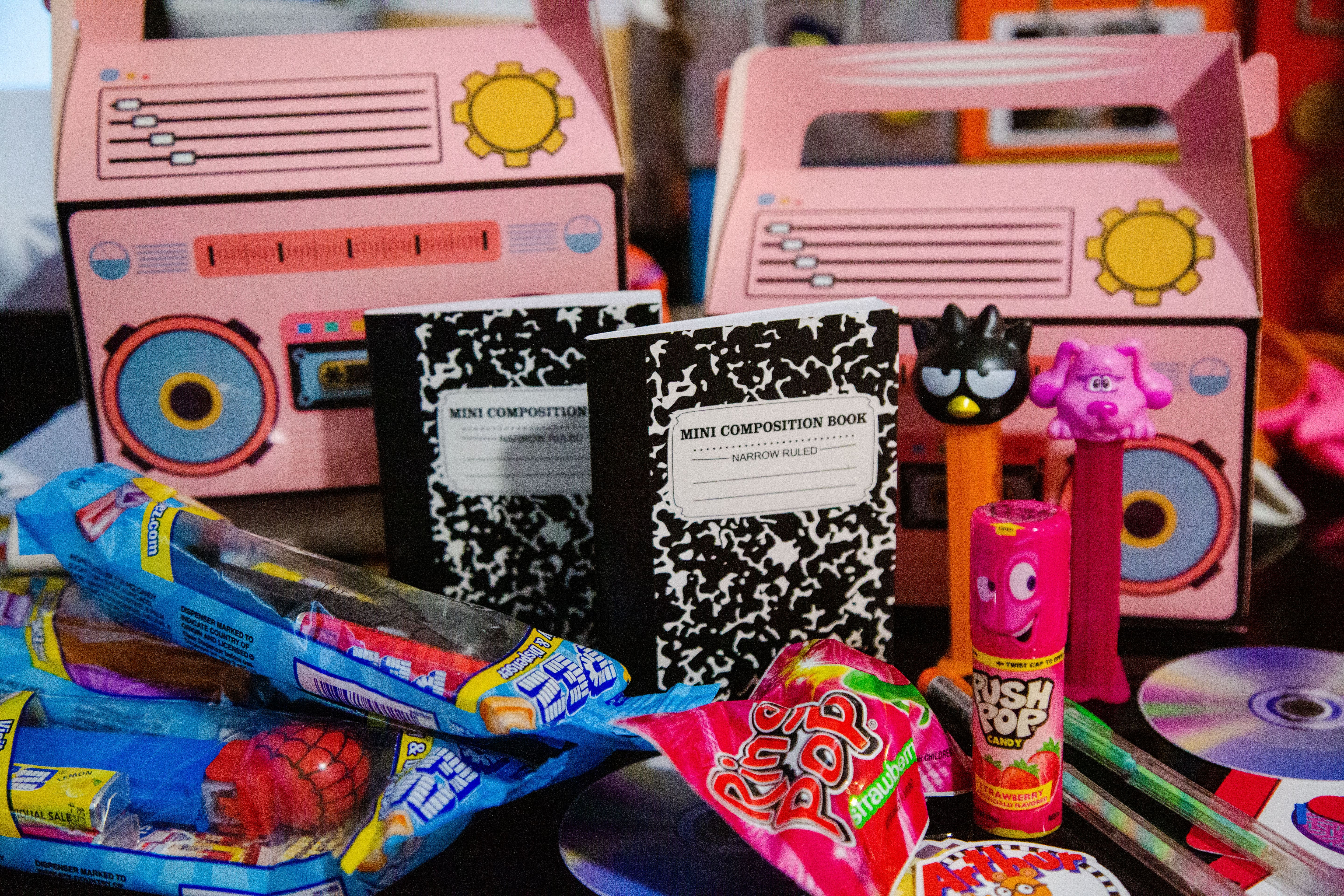 90s theme birthday party favor boxes, boomboxes, PEZ dispensers, ring pop, push pop, gel pens, mini composition notebooks