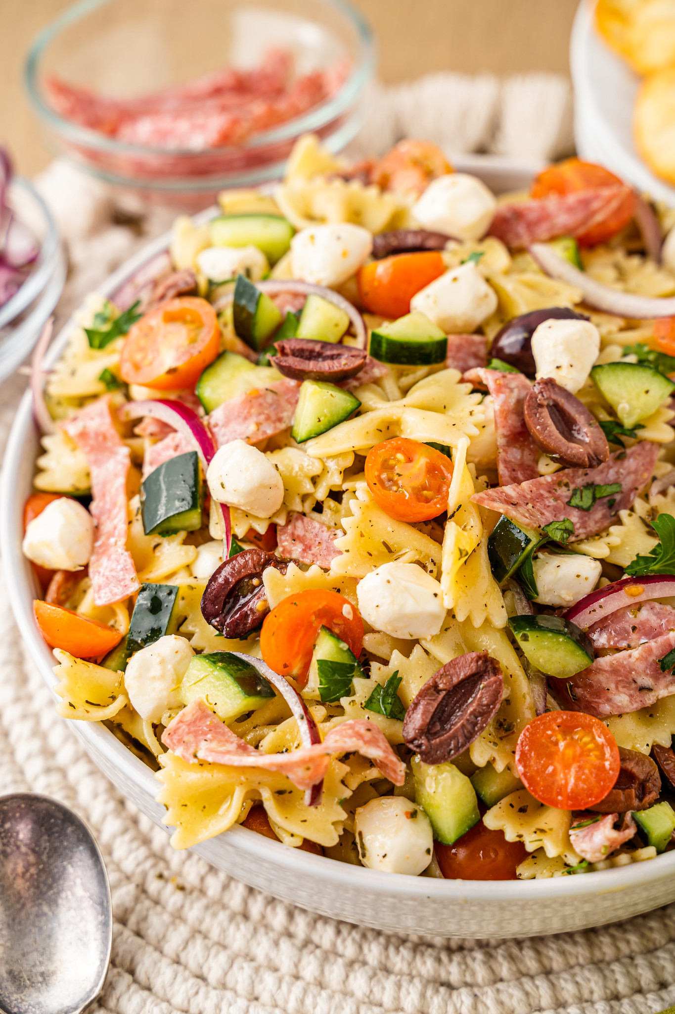 Italian Pasta Salad is the perfect side dish for spring and summer! Pasta, salami, mozzarella, olives, cucumber, red onion and tomato in an easy homemade dressing.