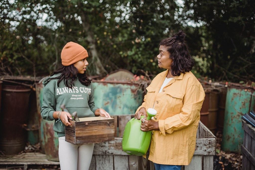 Two women gardening outside, engaged in conversation - What is a Mentor?