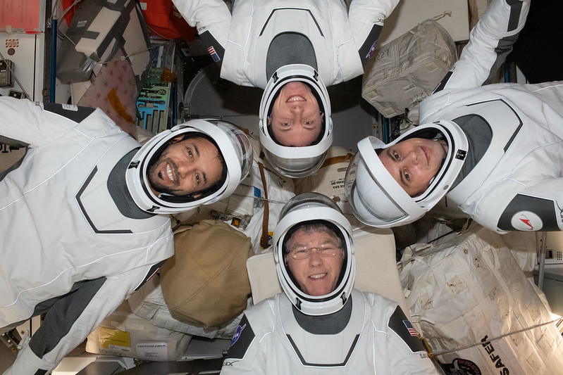 Expedition 69 crewmates pose in SpaceX pressure suits