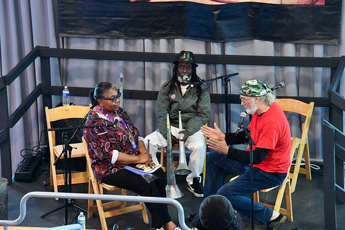 Haitian Rara: Members of RAM from Haiti on the Allison Miner Stage with interviewer: Maryse Dejean. Photo by Michael White.