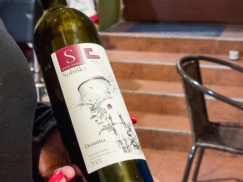 A bottle of red wine, with the name Domina on it