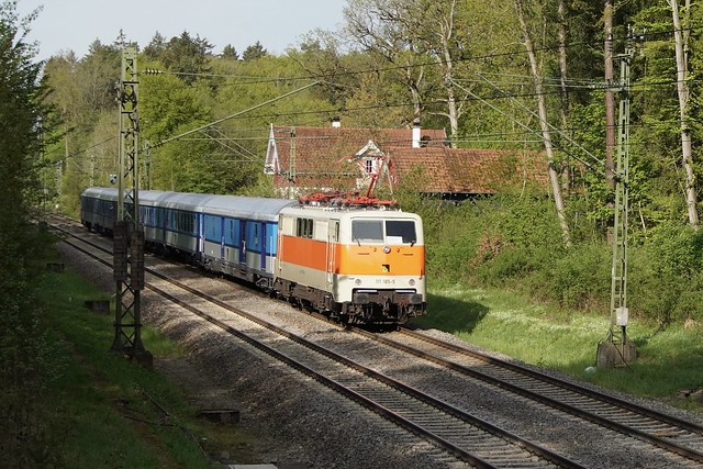 111 185 schiebt am 7.5.2023 den „FEX Südbahn“ (SVG 19995) von Stuttgart nach Konstanz durch den Sindelfinger Kaufwald.