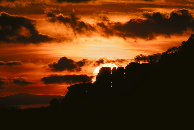 Sun sets behind the Hochstein rock formation in the Palatinate Forest