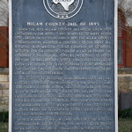 Old Milam County Jail (Cameron, Texas) Historical marker for the old Milam County Jail in Cameron, Texas.  The plaque reads:

When the 1875 Milam County Jailhouse grew too crowded in the 1890s, it was removed to make room for larger facilities. In March 1895, the Milam County Commissioners awarded a contract to the Pauly Jail Building and Manufacturing Company of St. Louis, Missouri, for the construction of a larger prison. The company furnished all supplies, including St. Louis pressed bricks. County Judge Sam Streetman, who later served on the Texas Supreme Court, approved the contract, although he had preferred the use of local building materials. This structure, designed with Romanesque revival features and stone detailing above the windows, had three main floors and a &amp;quot;hanging tower&amp;quot; equipped with a trap door. The tower was never used for executions because most hangings took place outdoors. The first floor had ten rooms, three for storage and the remainder serving as a residence for the sheriff and his family. The second and third stories consisted of cell blocks for prisoners. In 1975 a new county jail was constructed, and the Commissioners Court turned this facility over to the Milam County Historical Commission. After renovation, it was opened as a museum in 1978. Recorded Texas Historic Landmark - 1978