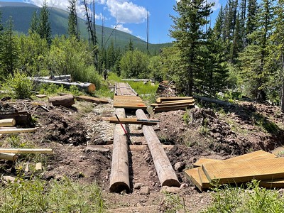 The Mineral Creek Trail Puncheon being built. The puncheon is two logs laid down parallel with the trail, and tread boards installed to act as a walkway.