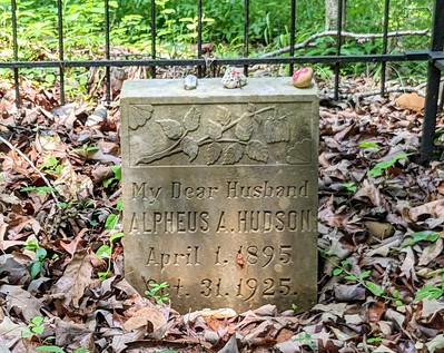 grave surrounded by an iron fence with the name Alpheus Hudson