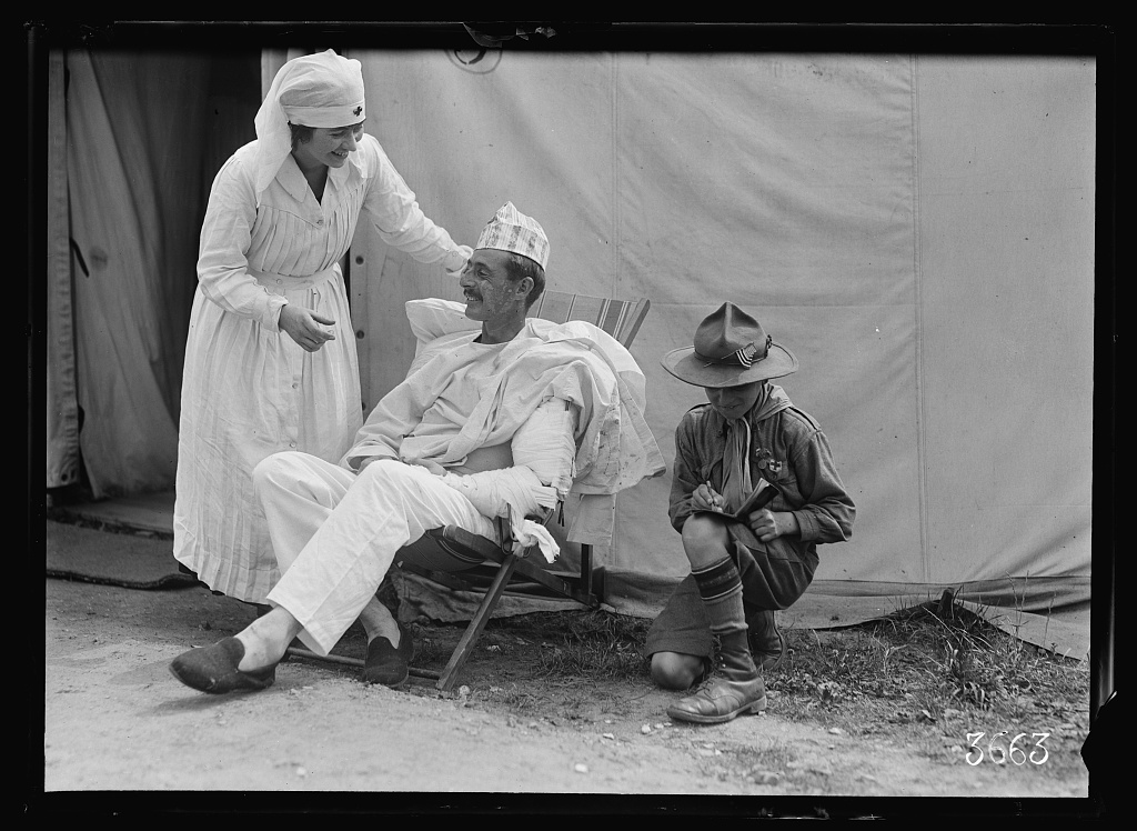 With an American Red Cross nurse's aid to look after his comfort and a boy scout run his errands this wounded American soldier has all he could ask for at American Military Hospital No. 5 at Auteuil supported by the American Red Cross (LOC)