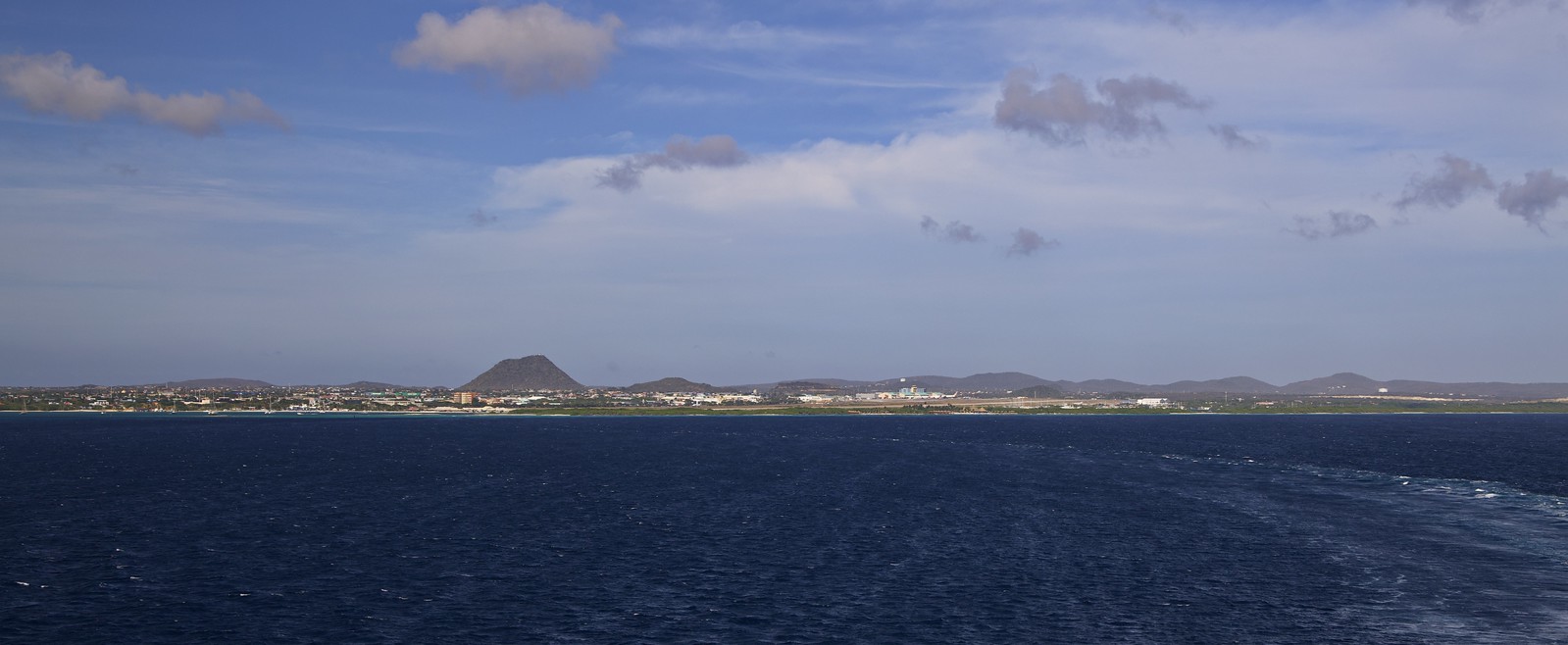 Panorama of coastal Oranjestad from the sea as the ship departs the harbour