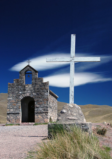 Shrine with a cross against the blue sky and desert clouds in the High Andes of Argentina