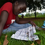 An adolescent girl reading a flier on HIV self-testing..