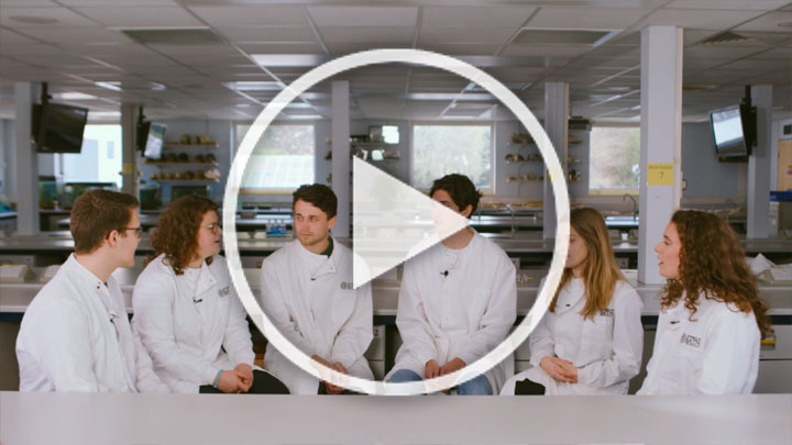 A group of biosciences students sitting in a semicircle in a lab