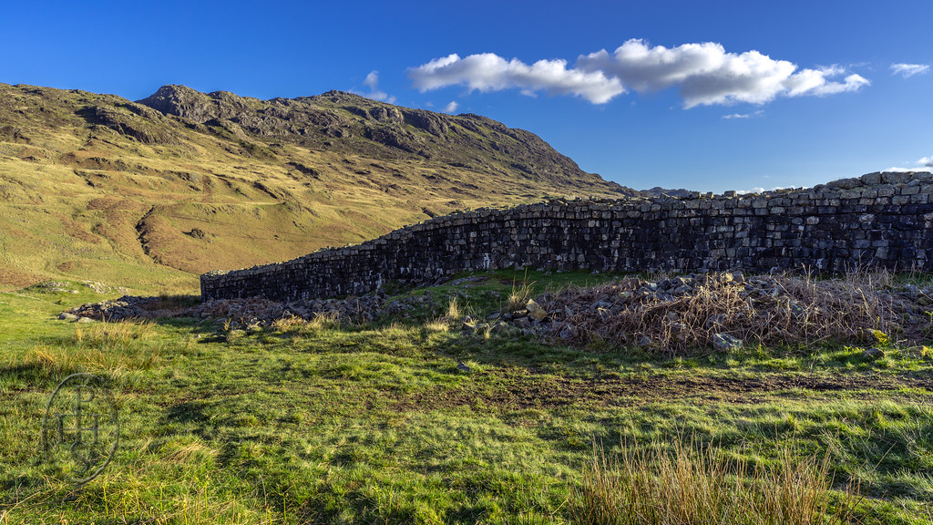 Mediobogdum Roman Fort Wall slightly rebuilt defending history and evoking mystery against a backdrop of towering majesty in Eskdale 1 of 4