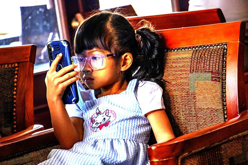 Severely nearsighted girl looking at cellphone at Subinh Hotel on 6-5-23--Pakse copy