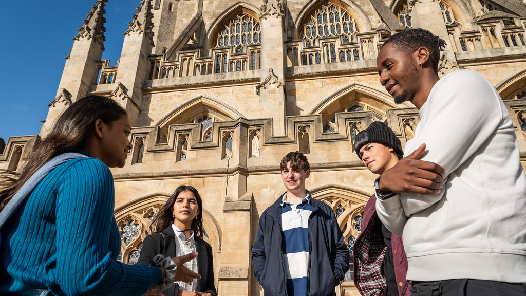Students talking in front of Bath Abbey.
