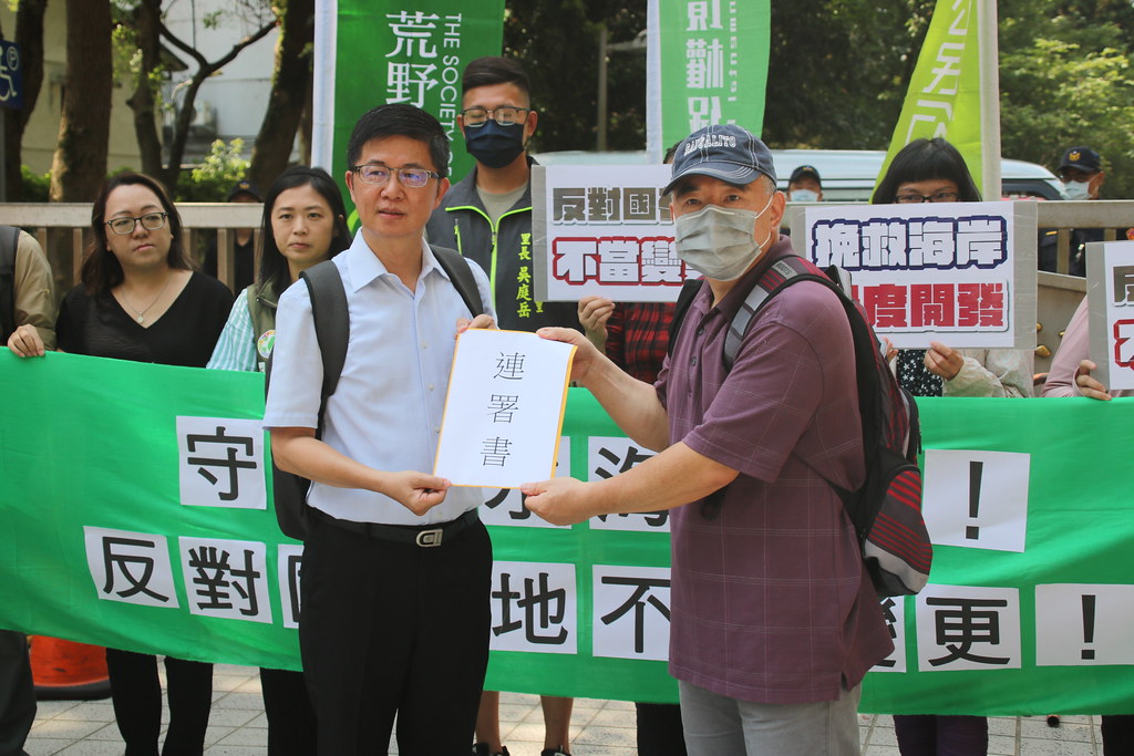 內政部營建署都市計畫組科長陳富義收下居民連署書。攝影：劉庭莉