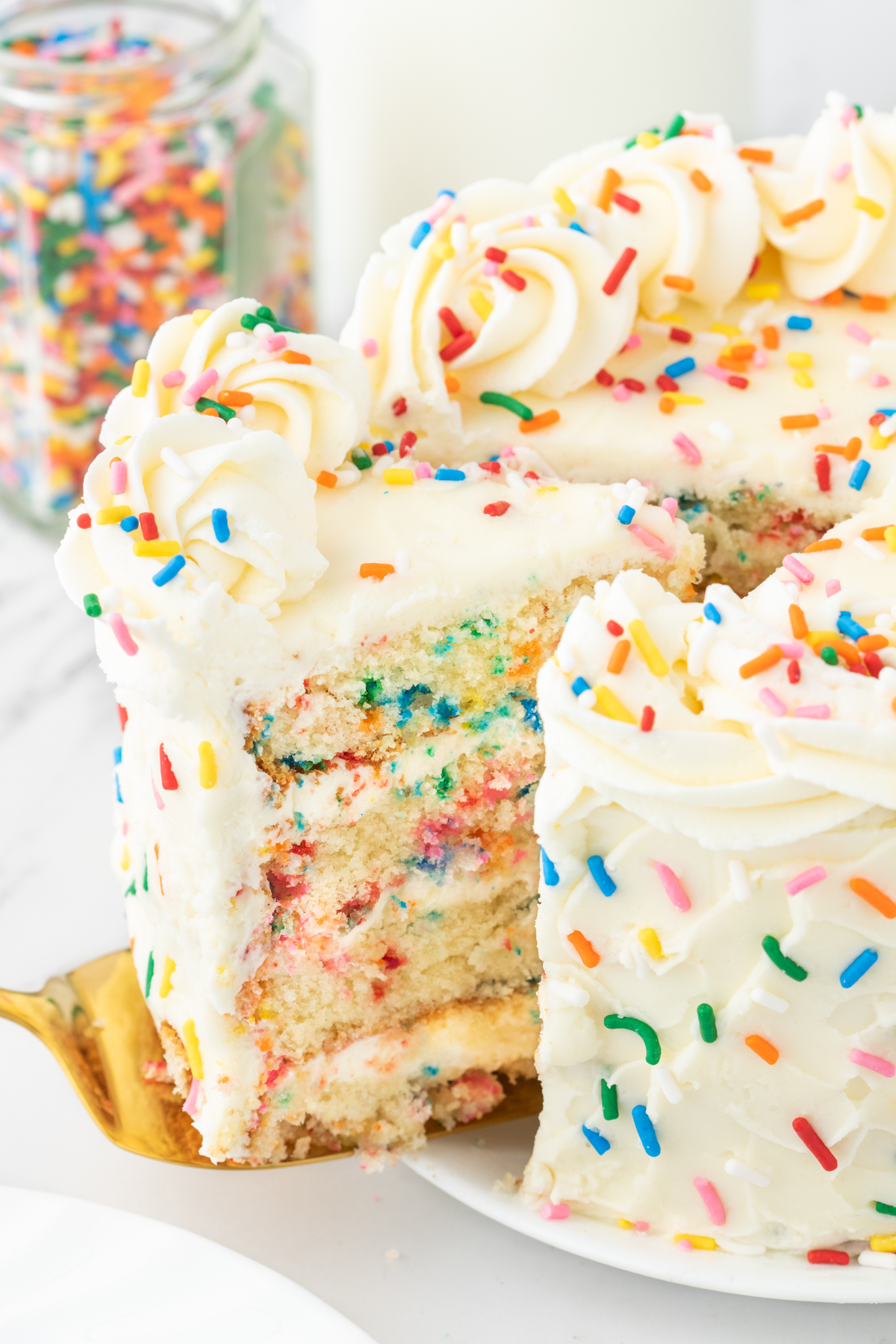 Funfetti Cake is the perfect birthday cake! Layers of moist vanilla cake filled with rainbow sprinkles. It gets filled and frosted with a delicious vanilla buttercream and topped with more sprinkles. 