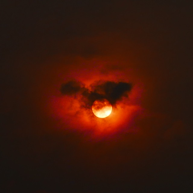 fast moving dark cloud and red sun