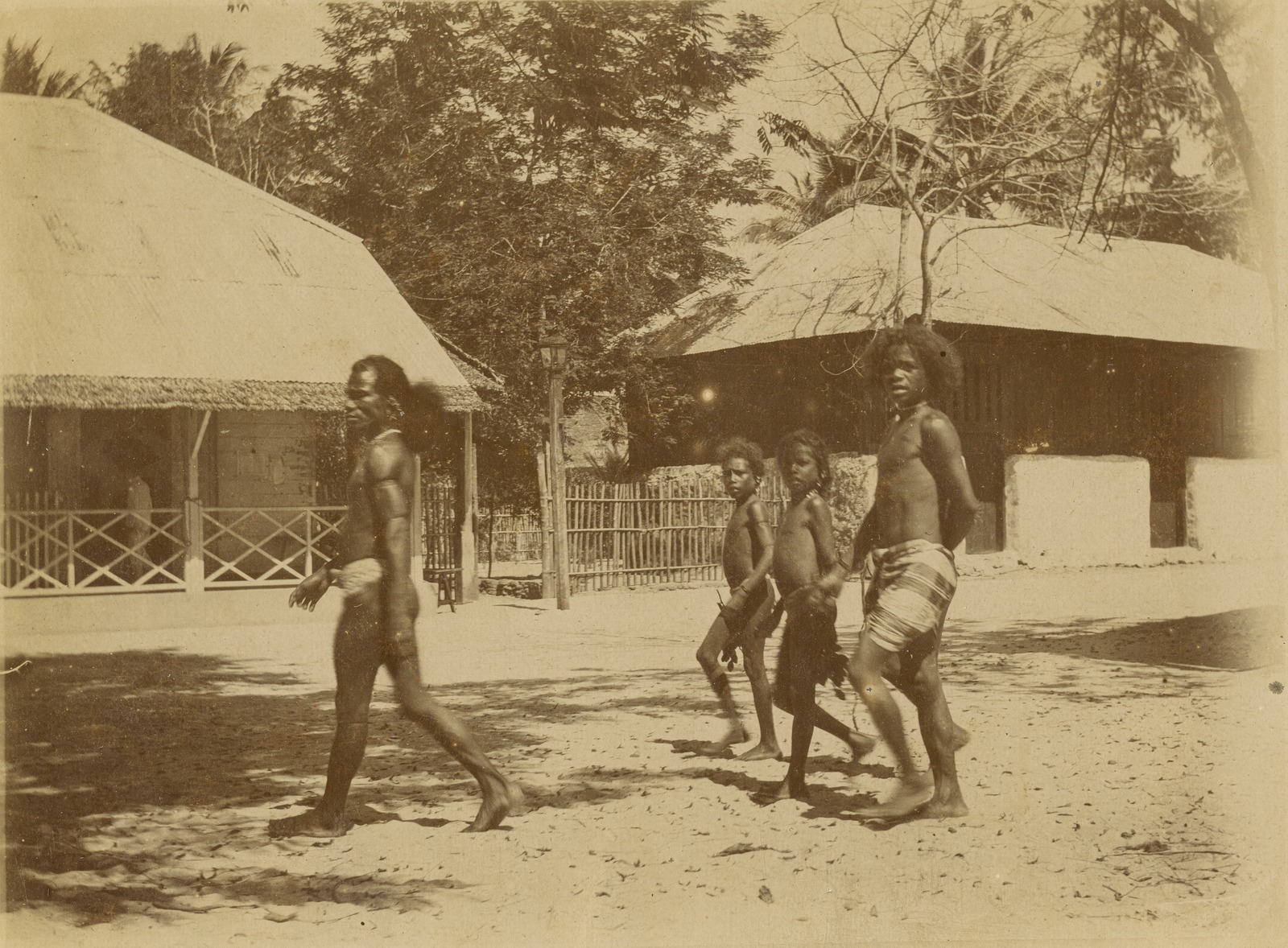 Aruese man and children walking in a street in Dobo, Warmar Islands, 1908
