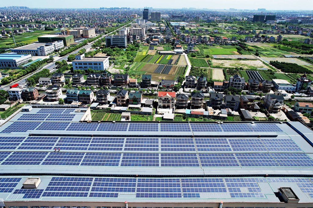 浙江蕭山一家工廠屋頂上的光電板。 中國政府2022年擴大再生能源的計劃要求至少一半的新工業園區和公共建築要安裝太陽能電池板。 圖片來源：Long Wei / Alamy