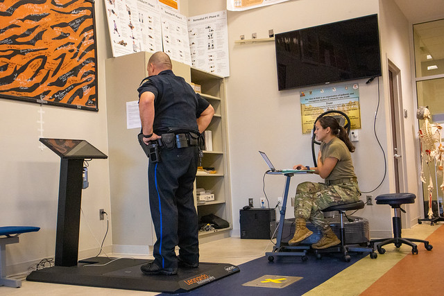 A soldier helps a police officer with a physical assessment at the Warrior Research Center.