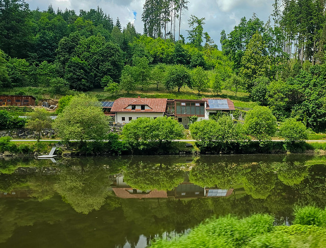 Houses and trees mirrored in river 