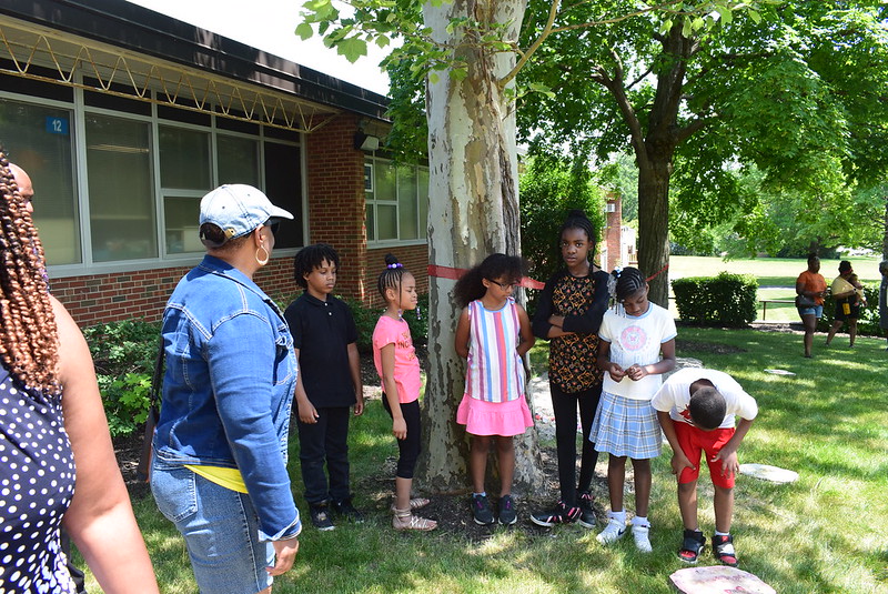 Children observe garden stones craften by Blackhawk students.