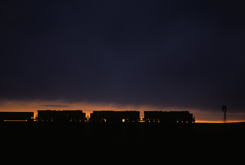 Sliver of a sunset by Moffat Road, The locomotives of a northbound BNSF coal train silhouettes against a subtle sunset on an otherwise 