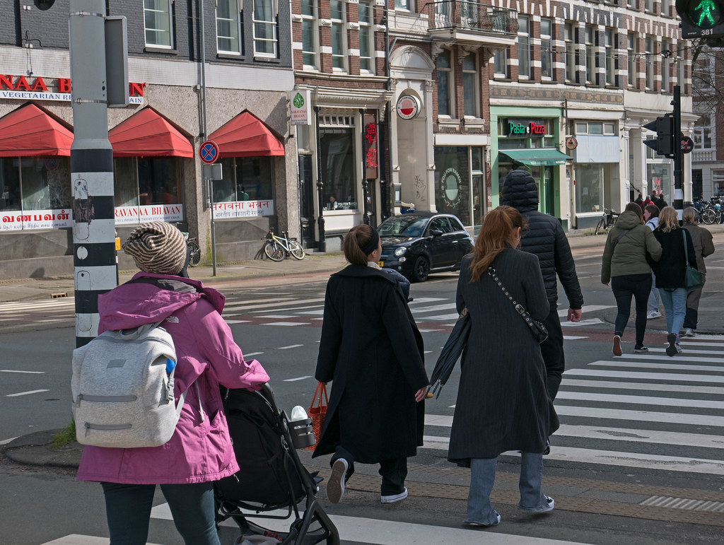 People are crossing the street in Amsterdam city, free photo 2023