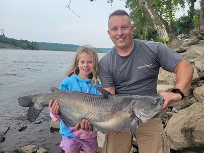 Photo of man and daughter holding a catfish