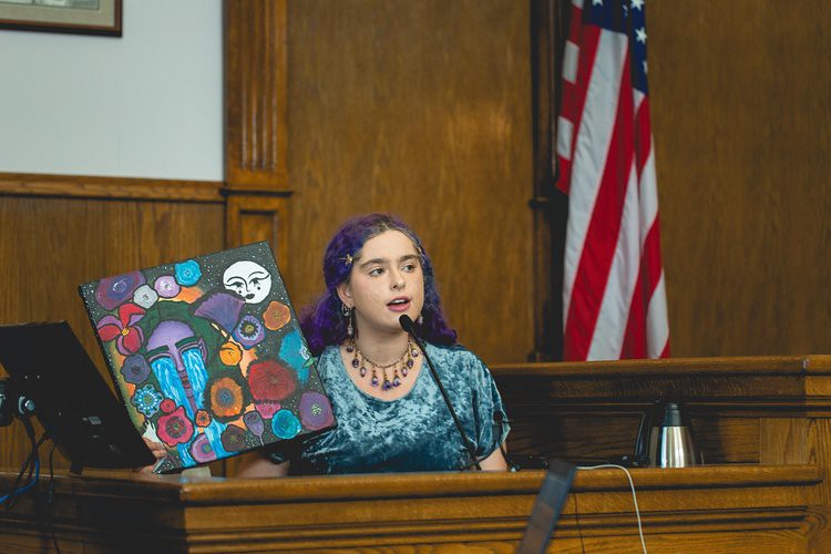 Youth plaintiff Olivia displays her art during testimony (Photo by Renata Harrison, Courtesy of Western Environmental Law Center)
