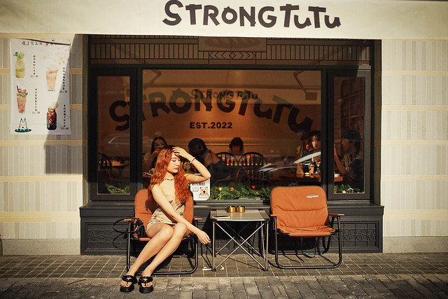 A girl sitting outside coffee shop