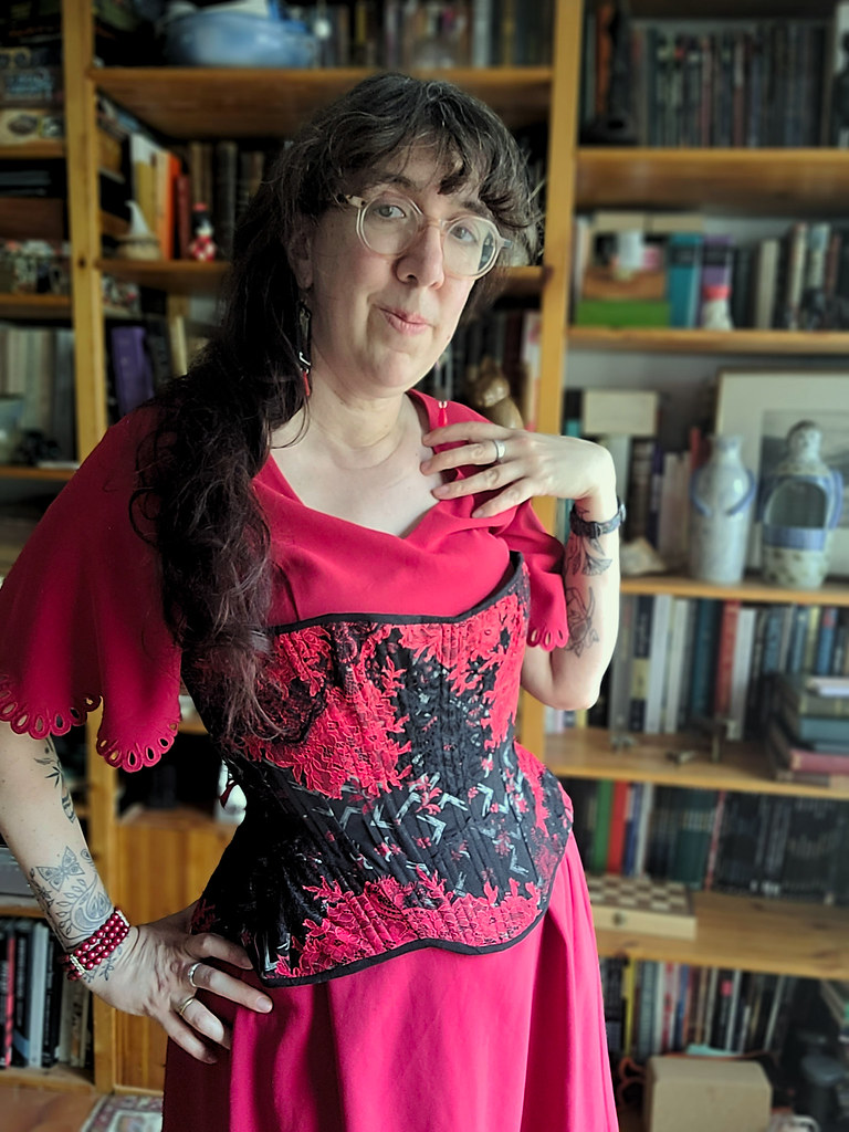 Femme portant un corset rouge et noir décoré de dentelles