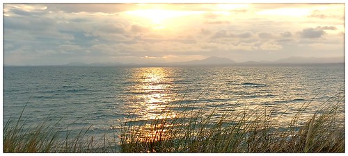 Sunset light by ohefin, And reflected along the sea at Llandanwg towards the marram grasse's on the beach.enjoyingretirement