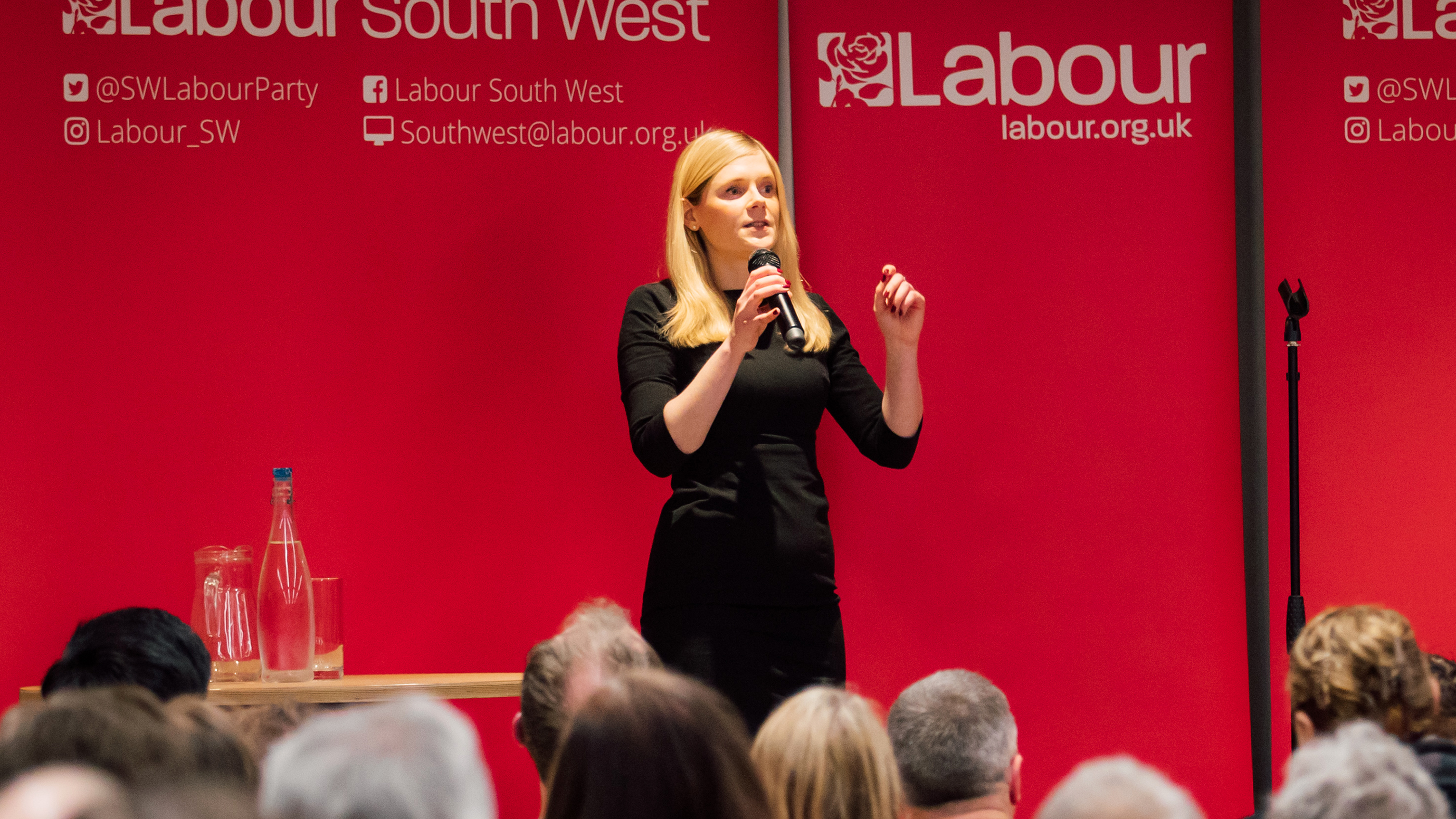 A woman (Claire Hazelgrove) speaking on stage at a Labour event.