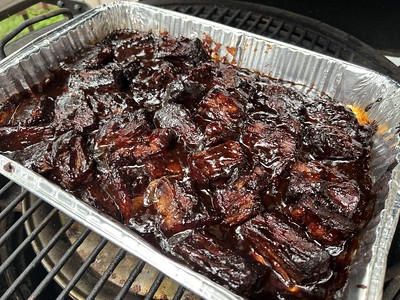 Cut up meat covered in brown sugar and BBQ sauce