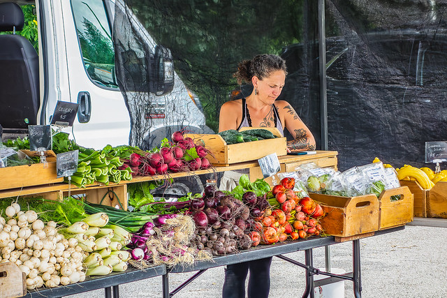 Woman tending vegetable stand